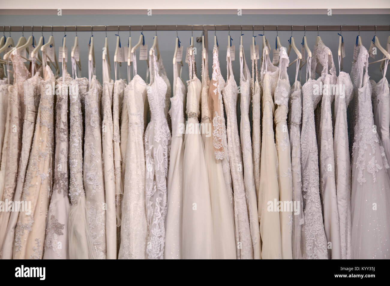 Wedding dresses hanging on clothes rack at store Stock Photo Alamy