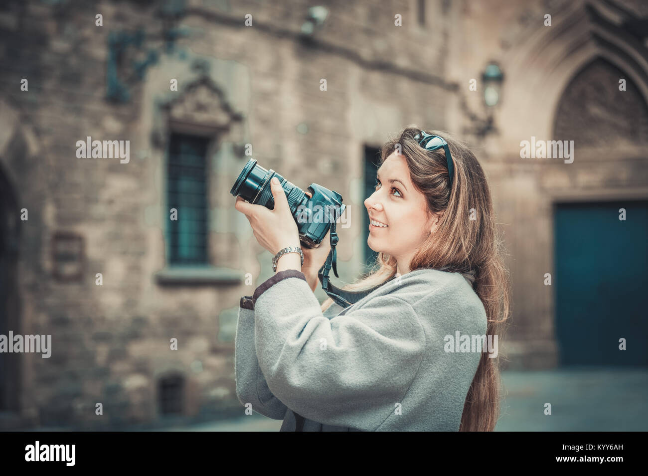Cheerful positive smiling young girl holding camera in hands and ...