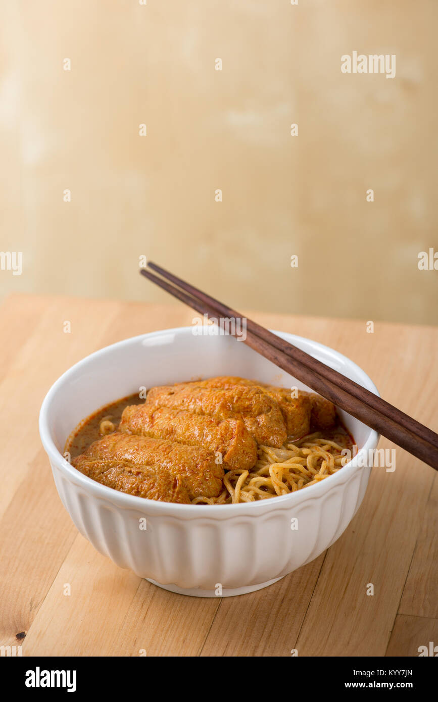 Hot and spicy Malaysian curry noodle with chopsticks on table Stock Photo -  Alamy
