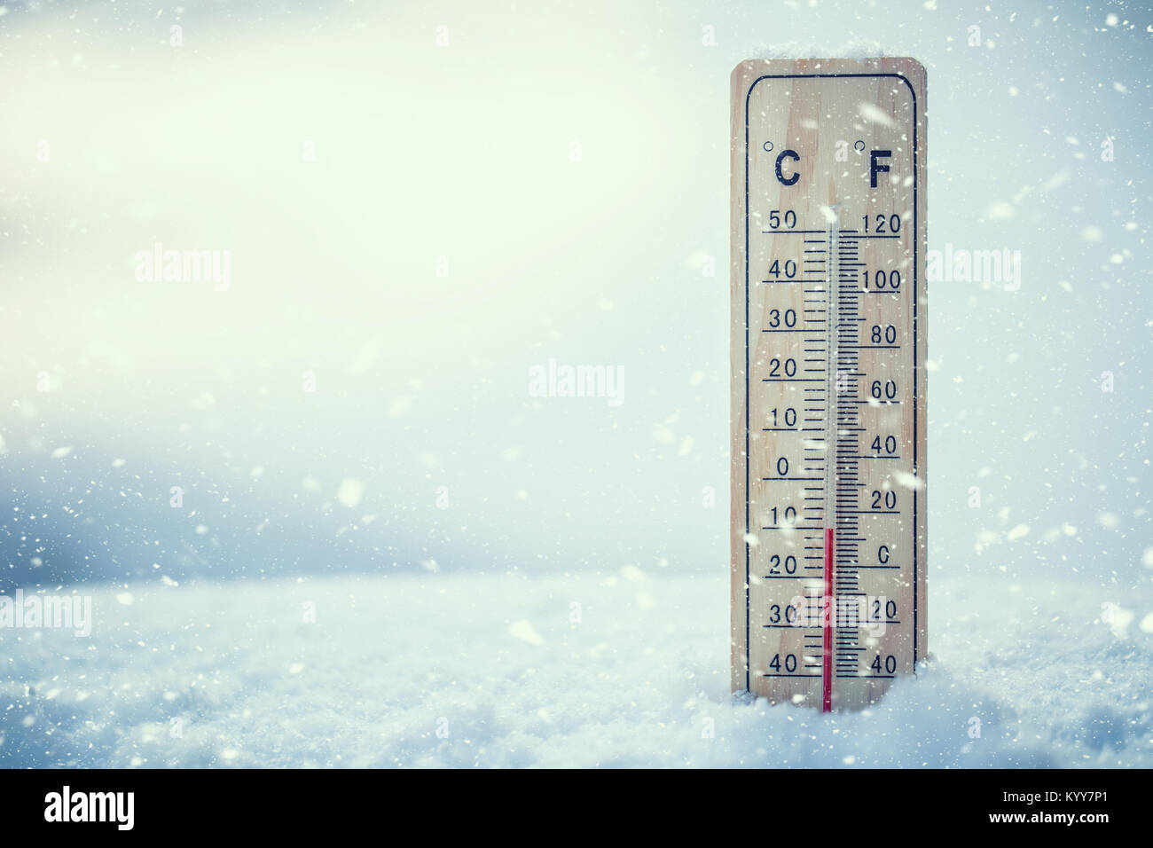 Thermometer on snow shows low temperatures under zero. Low temperatures