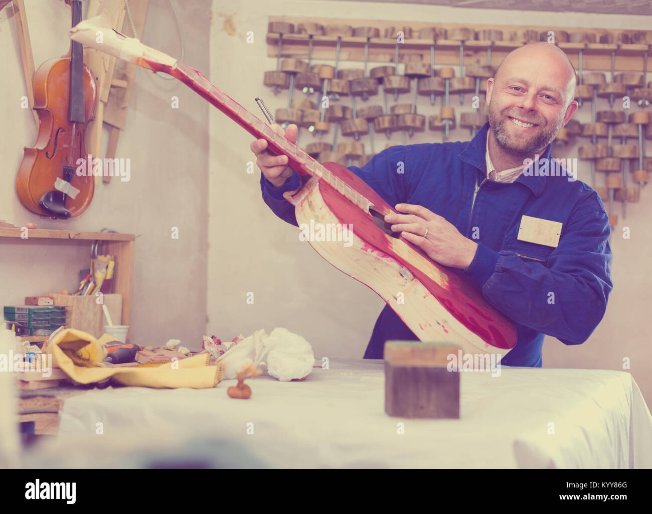 String Musicians Smiling Skilled smiling artisan creating a string musical instrument in a ...