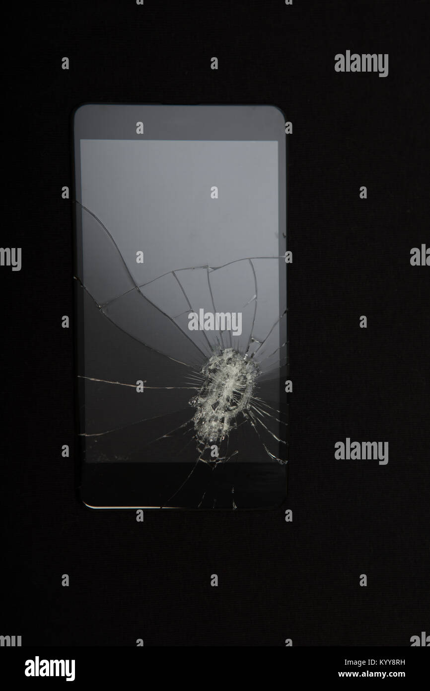 Close-up view of Shattered smartphone screen on black background with