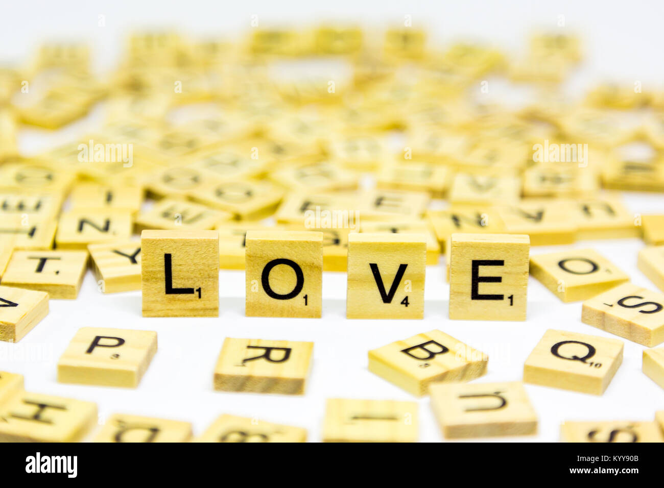 The word love standing up made from wooden scrabble letters on a white background Stock Photo