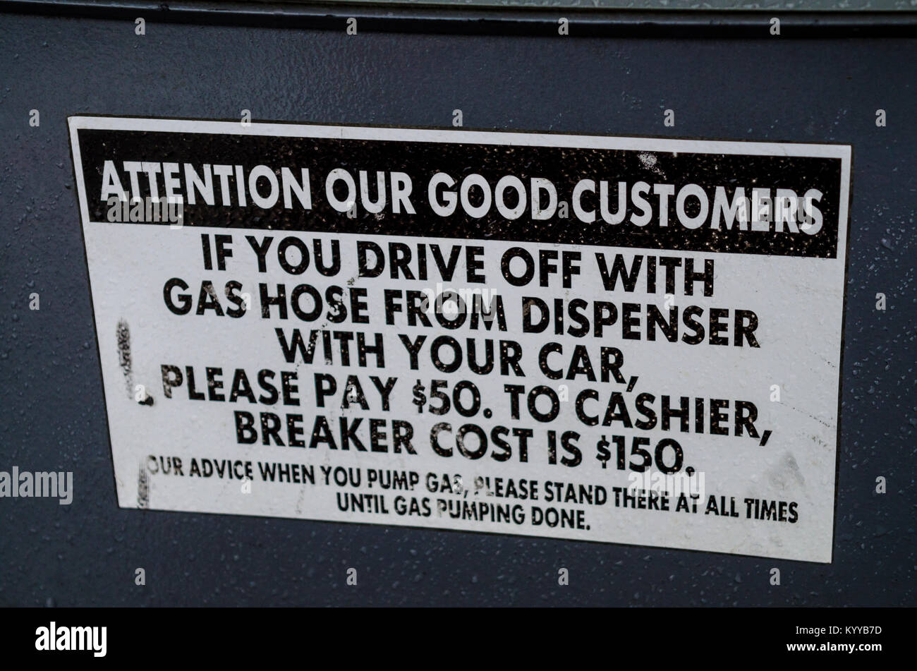 A warning sign at a Chevron gas station self serve pump about driving off without removing the nozzle from the gas tank. Stock Photo