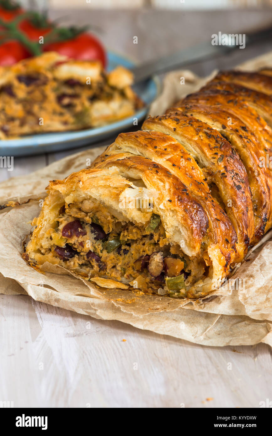Pork roll spicy sausage meat with chillies and beans in puff pastry