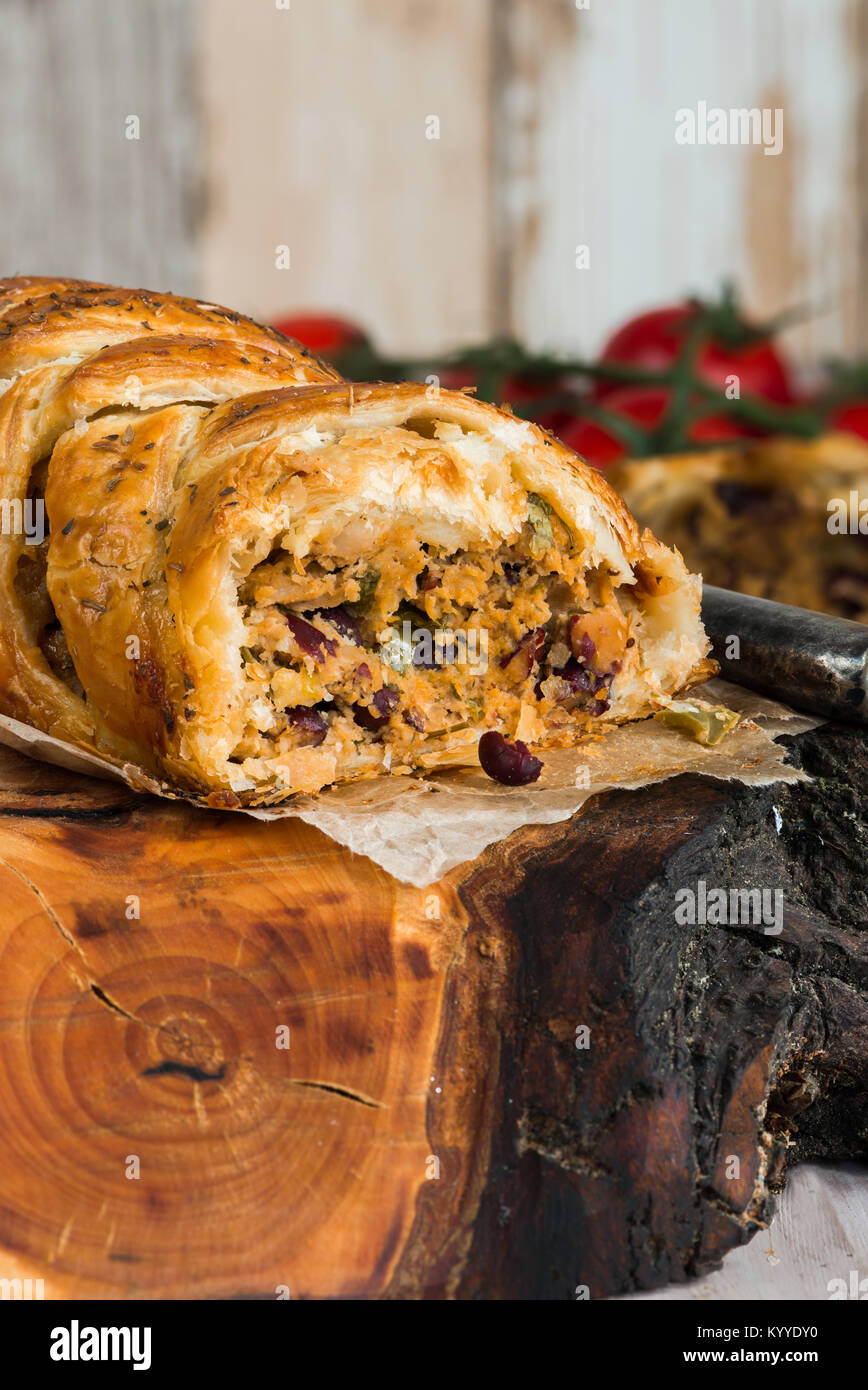 Pork roll spicy sausage meat with chillies and beans in puff pastry