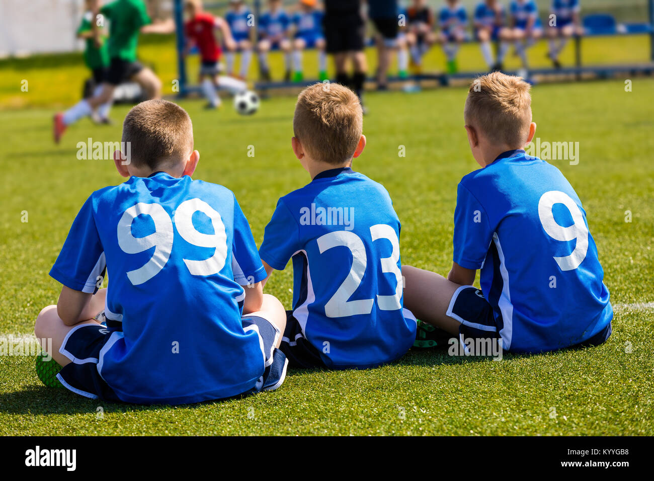 Children Soccer Team Watching Football Match. Children Sport Team in Blue Shirts. Youth Soccer School Tournament for Children. Young Boys in Soccer Je Stock Photo