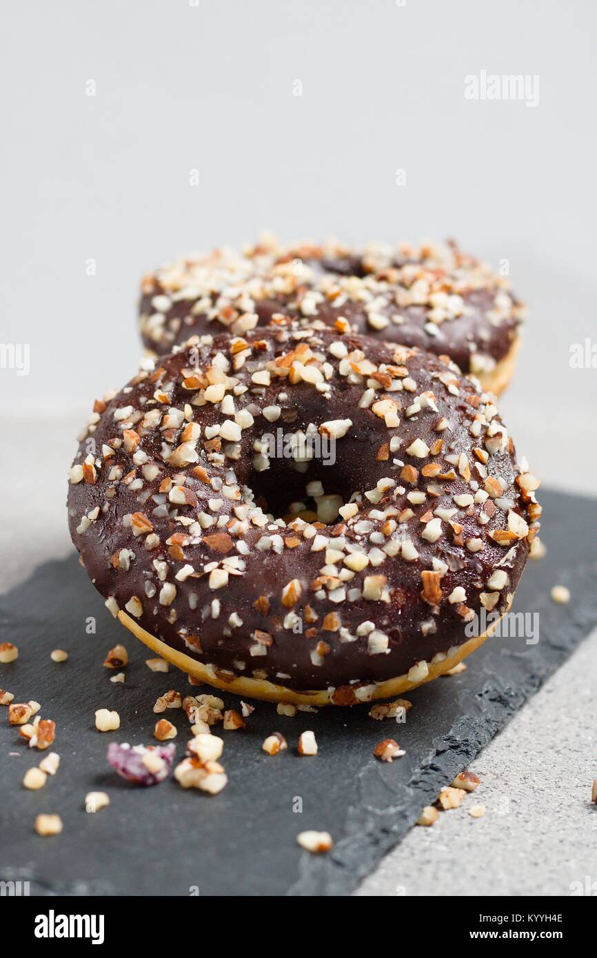 Several chocolate glazed donuts with chopped nuts Stock Photo Alamy