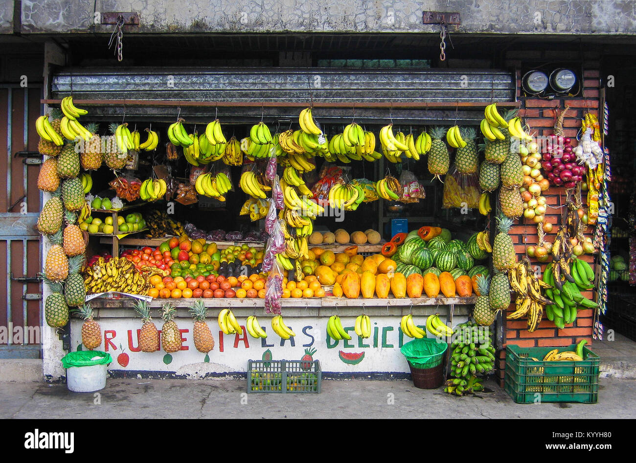 Well stocked fruit shop and green grocer's brightening a dingy street in Alajuela a large town in central Costa Rica Stock Photo