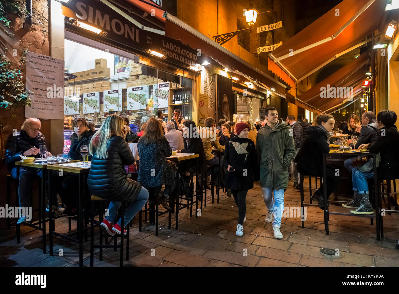 Bologna, Italy - people out for the evening eating and drinking in cafes and restaurants in Via Pescherie Vecchie, Bologna city Stock Photo