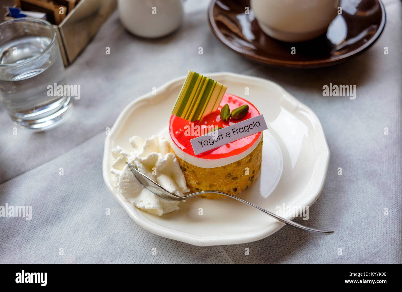 Italian yogurt and strawberry topped cake in a cafe in Italy Stock