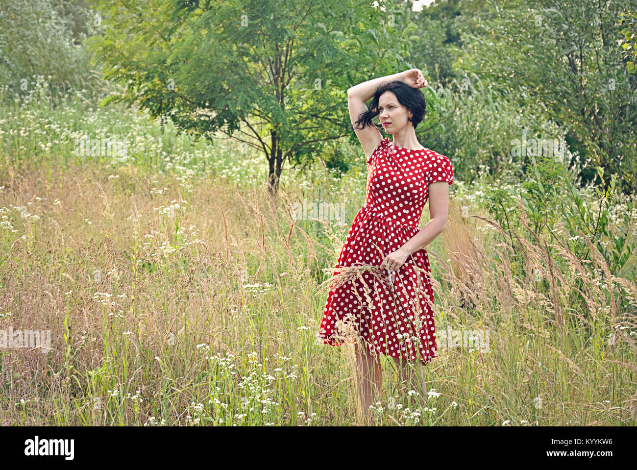 Woman in summer dress walking in field Stock Photo - Alamy