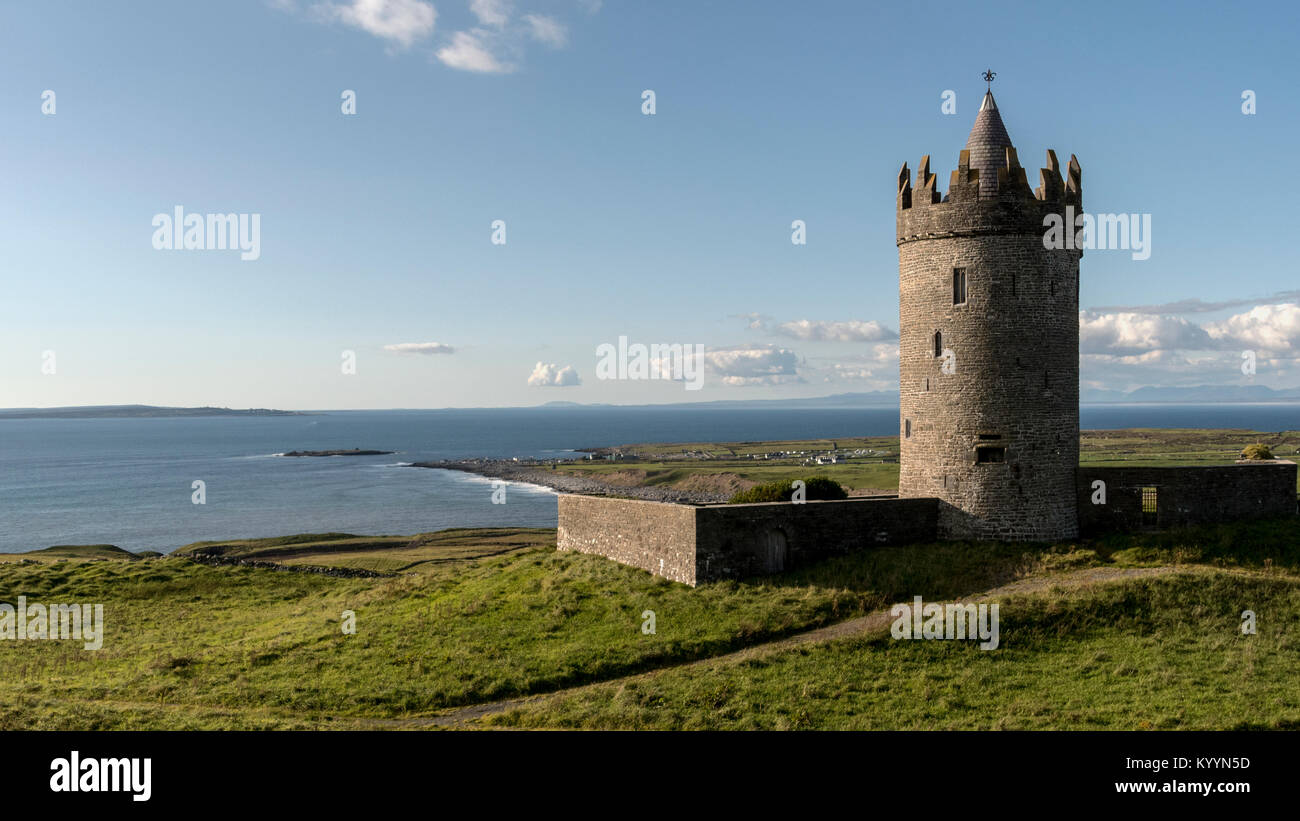 Doonagor Castle in Ireland which overlooks the village of Doolin at the foot of the Cliffs of Moher. The Aran Islands can be seen in the distance. Stock Photo