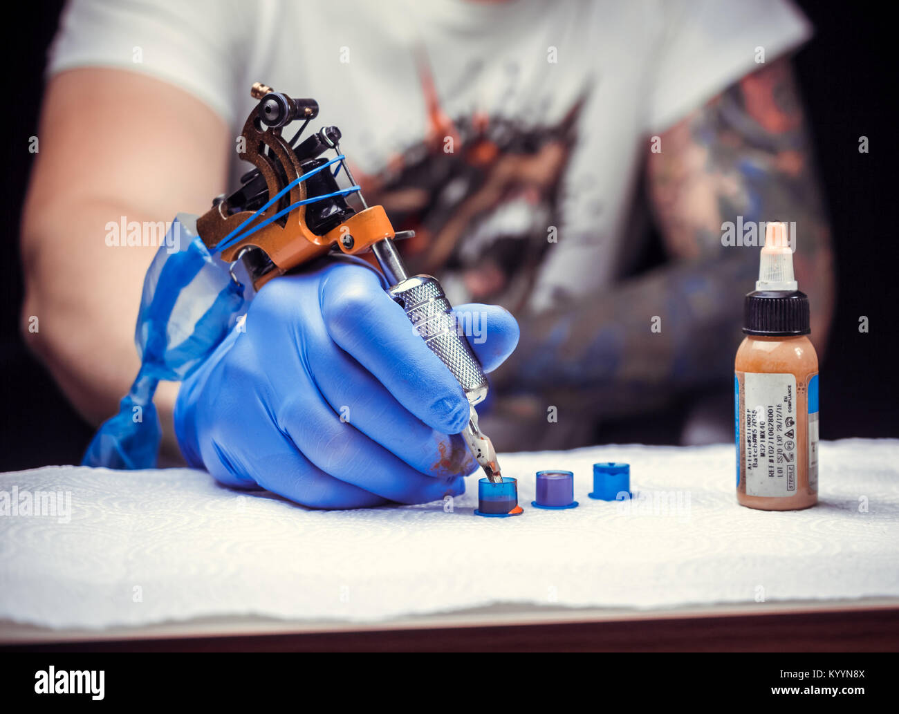 Hand of a tattooist, holding the tattoo gun Stock Photo Alamy
