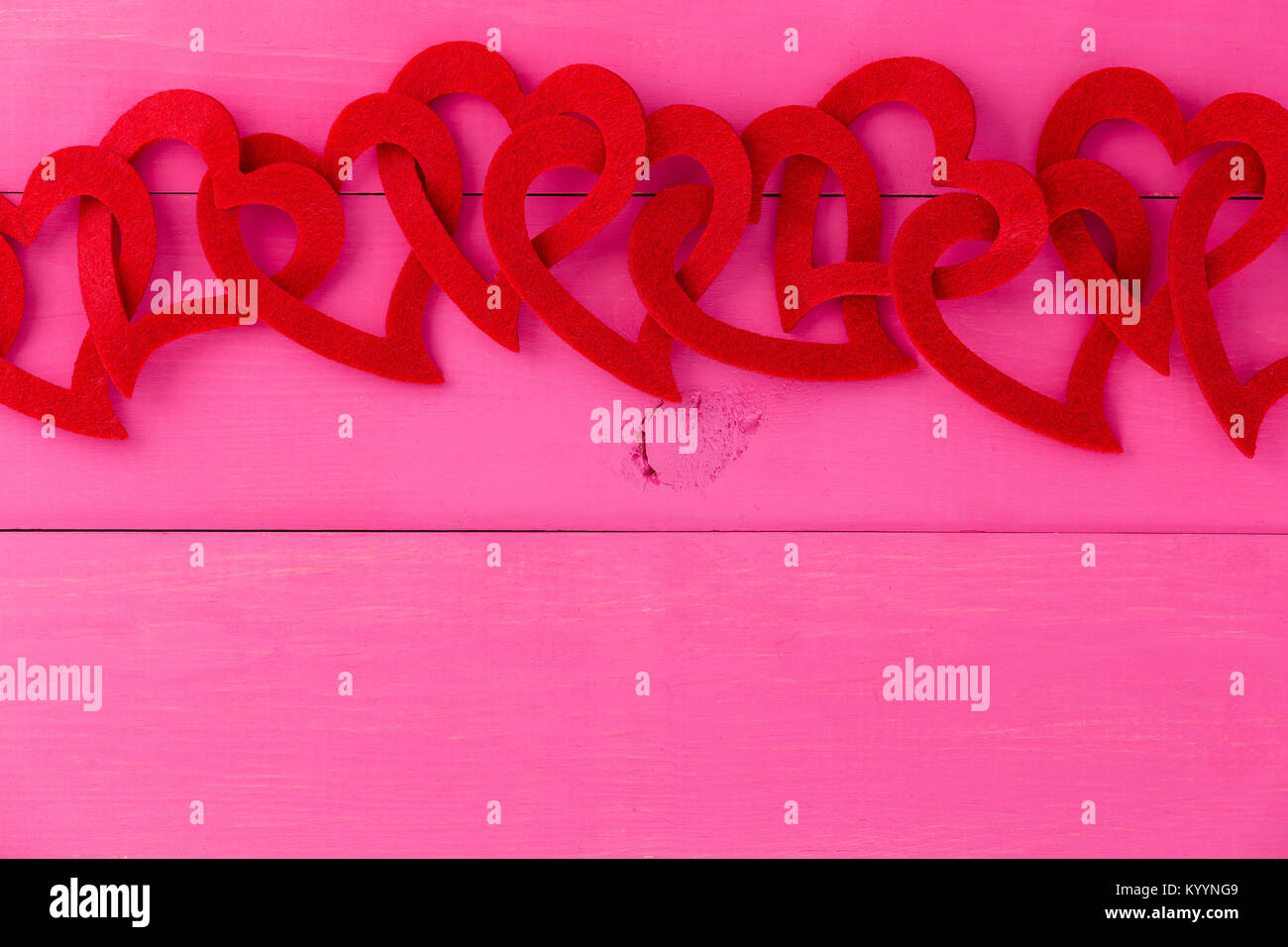 Red heart border for romance and love over a shocking pink background with copy space for your Valentines, wedding or anniversary greeting Stock Photo