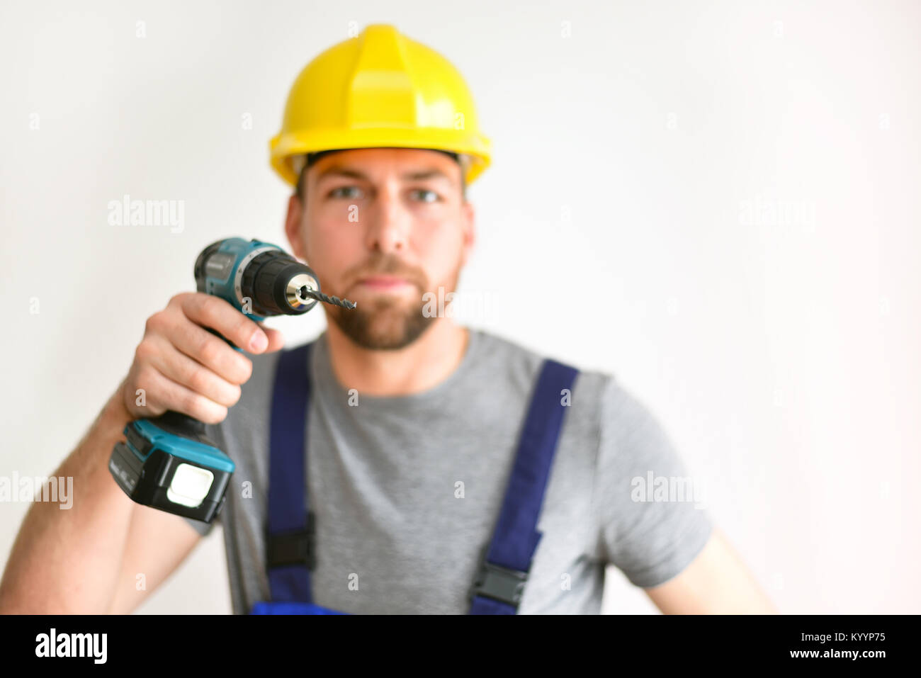 freestanding craftsman construction worker assembler with drilling machine - friendly worker in work clothes on white background Stock Photo