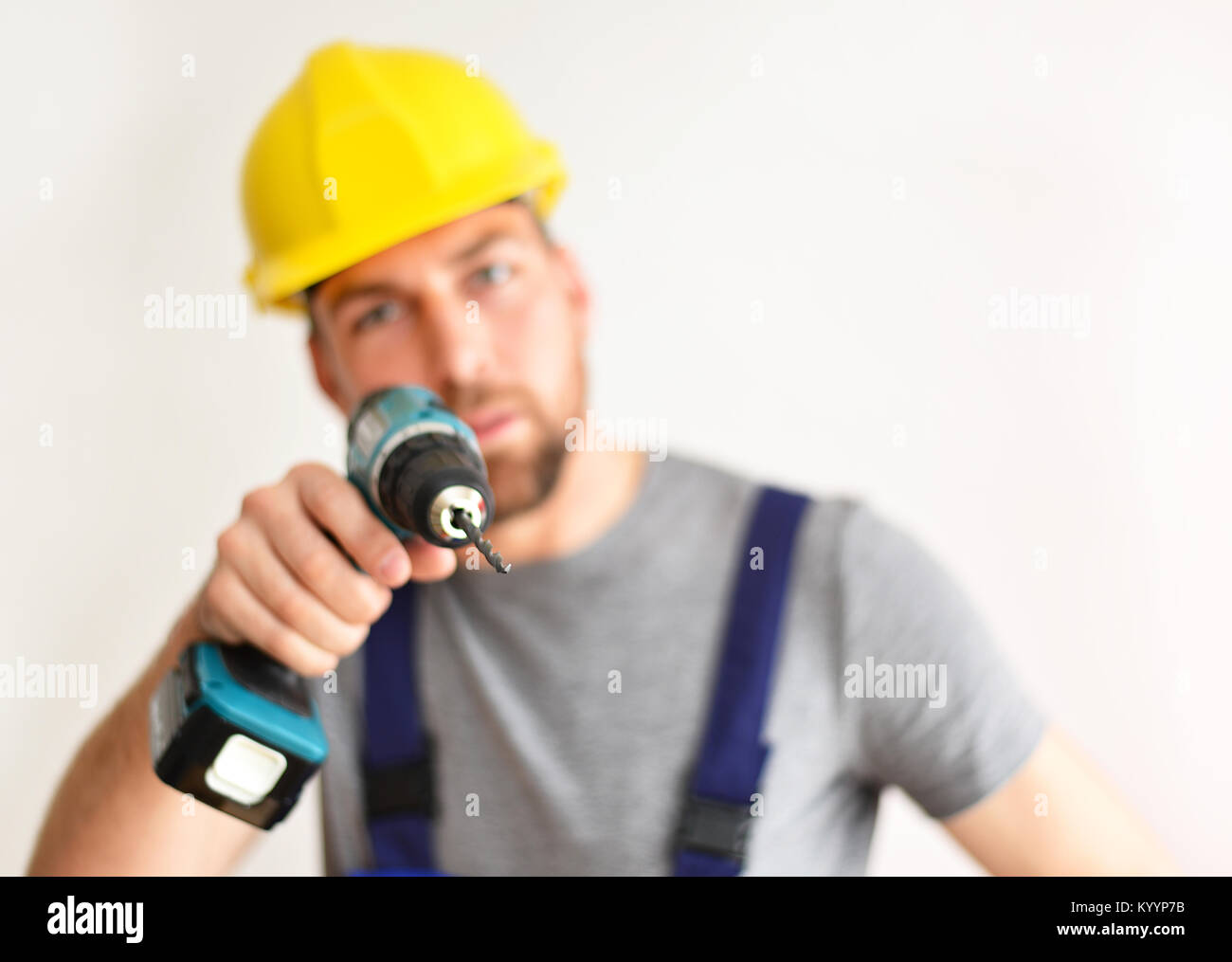 freestanding craftsman construction worker assembler with drilling machine - friendly worker in work clothes on white background Stock Photo