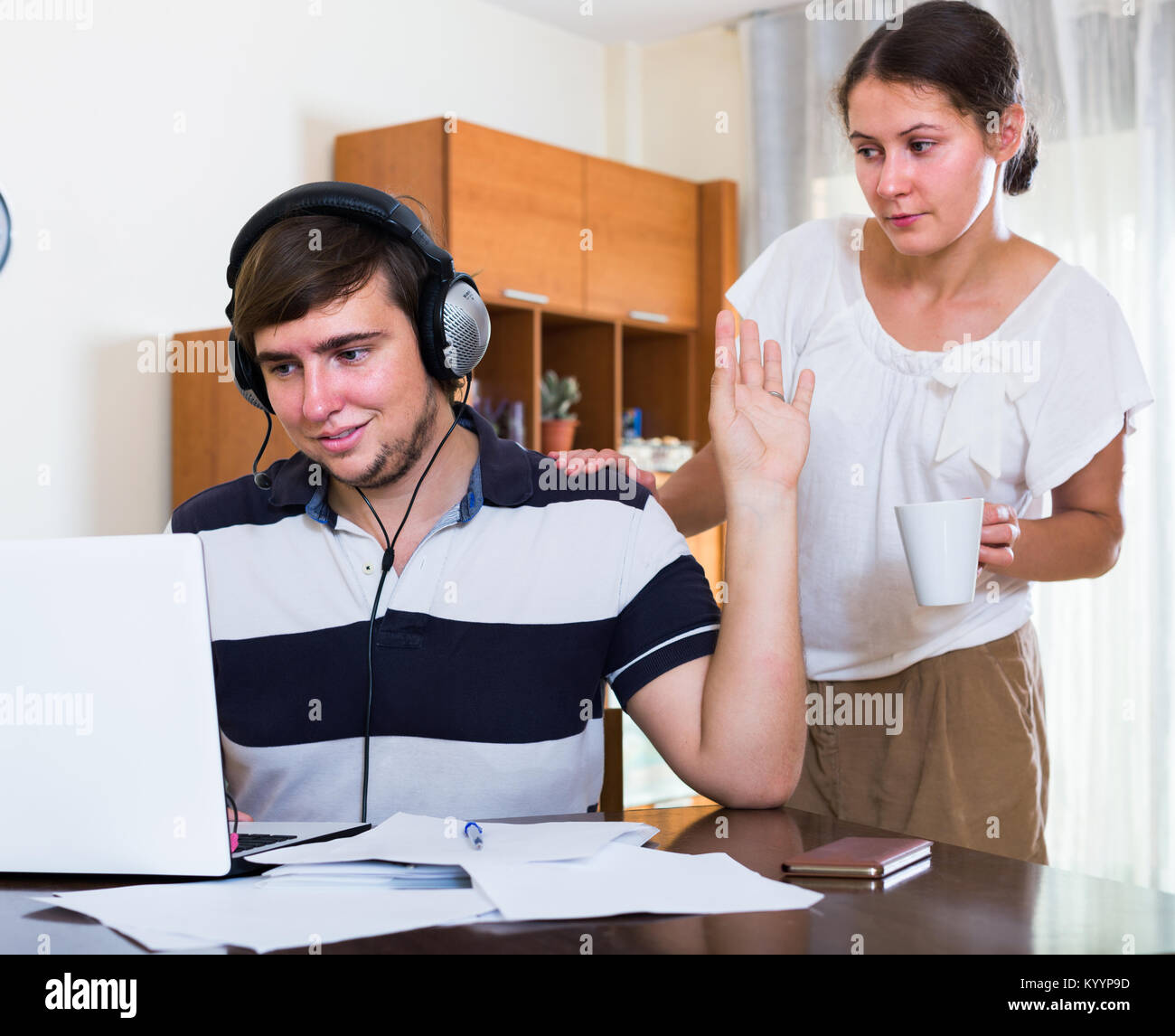 spouse and sad american  person with internet addiction at home. focus on man Stock Photo