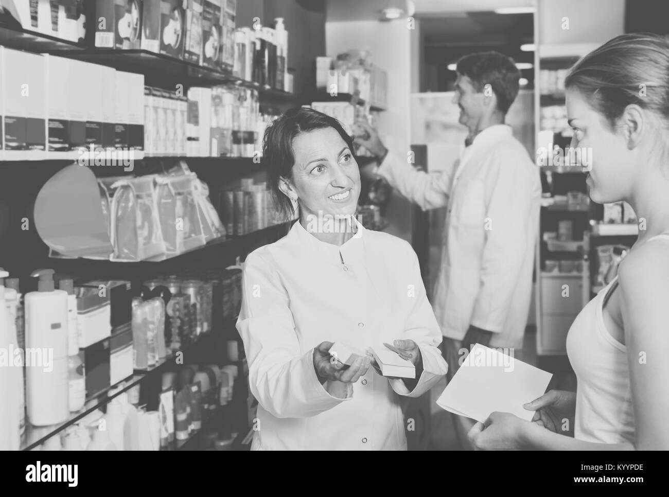 Smiling diligent  female pharmacist wearing uniform working in pharmaceutical shop Stock Photo