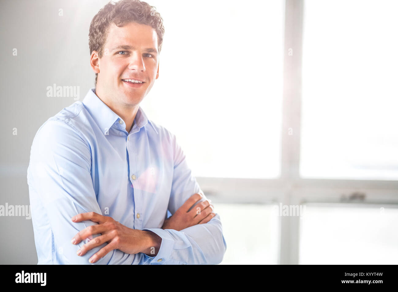 Portrait of businessman standing arms crossed in office Stock Photo - Alamy