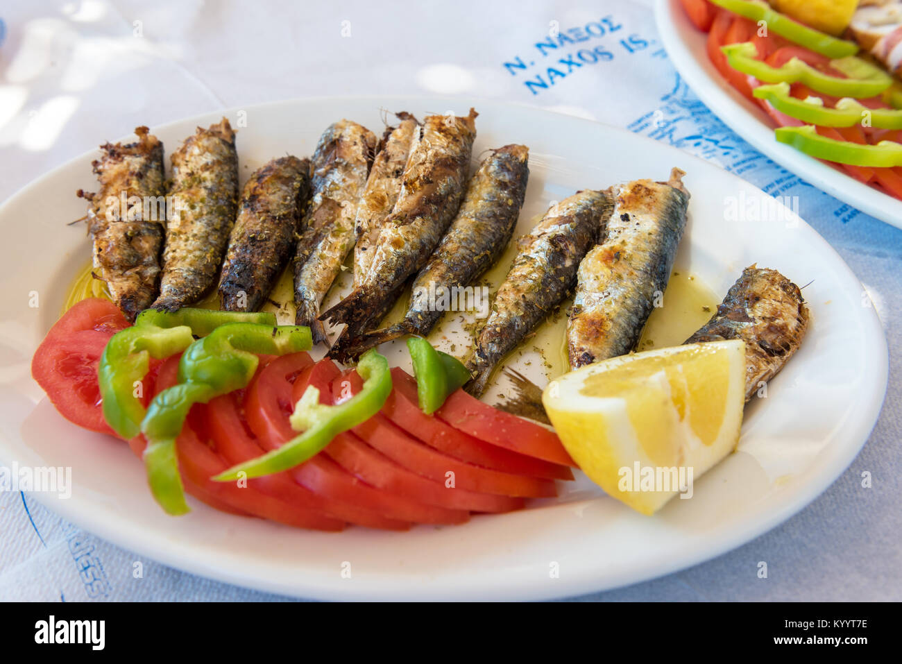 Seafood, grilled sardines served with vegetables in traditional Greek