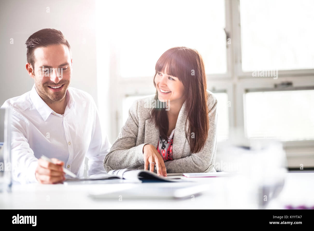 Smiling young business people discussing together in office Stock Photo ...