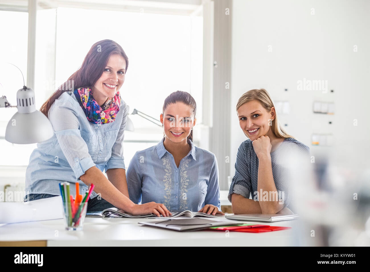 Portrait of young businesswomen working together in creative office ...