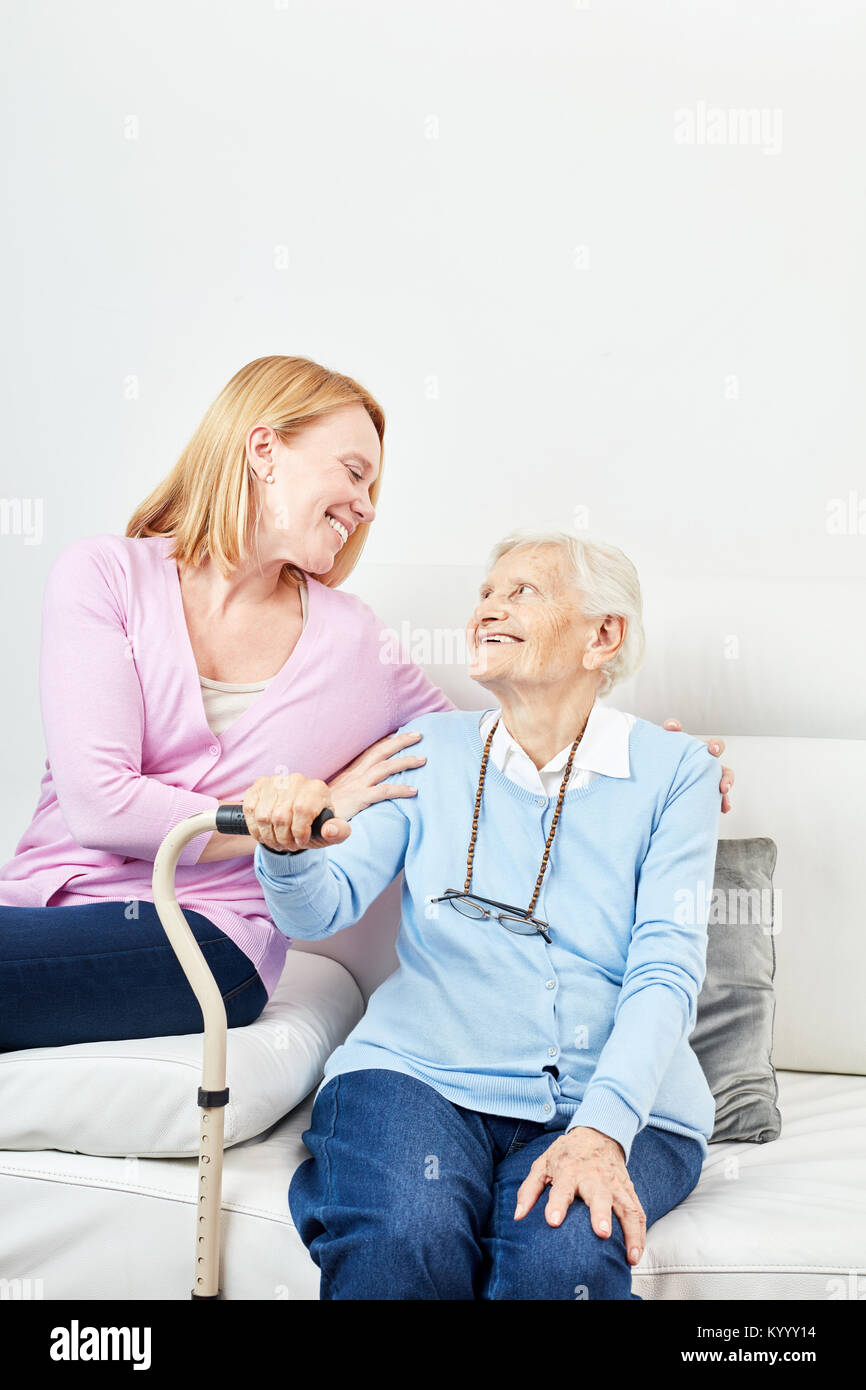 Young woman affectionately cares for a senior citizen in a retirement home or at home Stock Photo