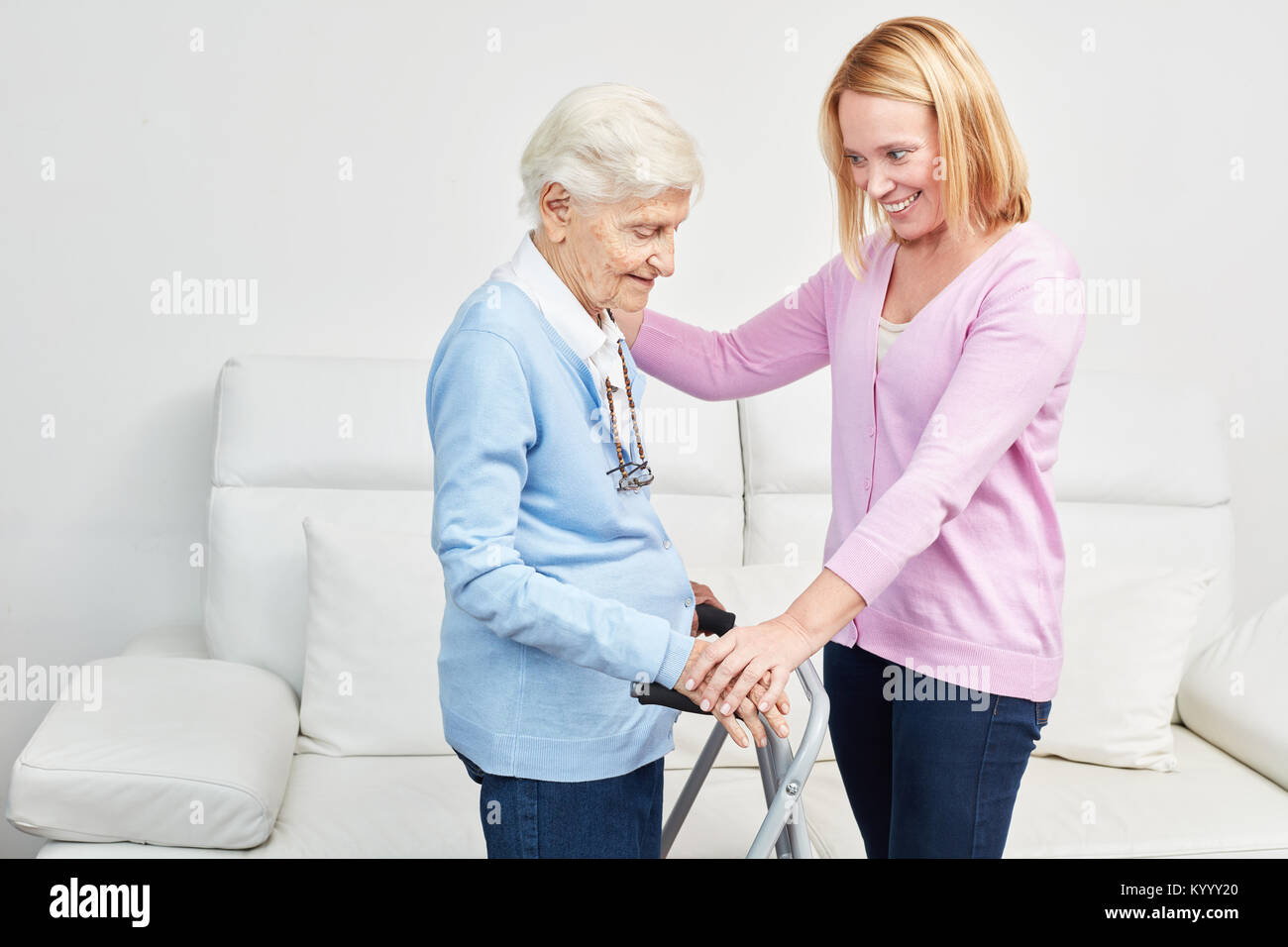Young woman as a daughter taking care of elderly woman as a mother at home Stock Photo