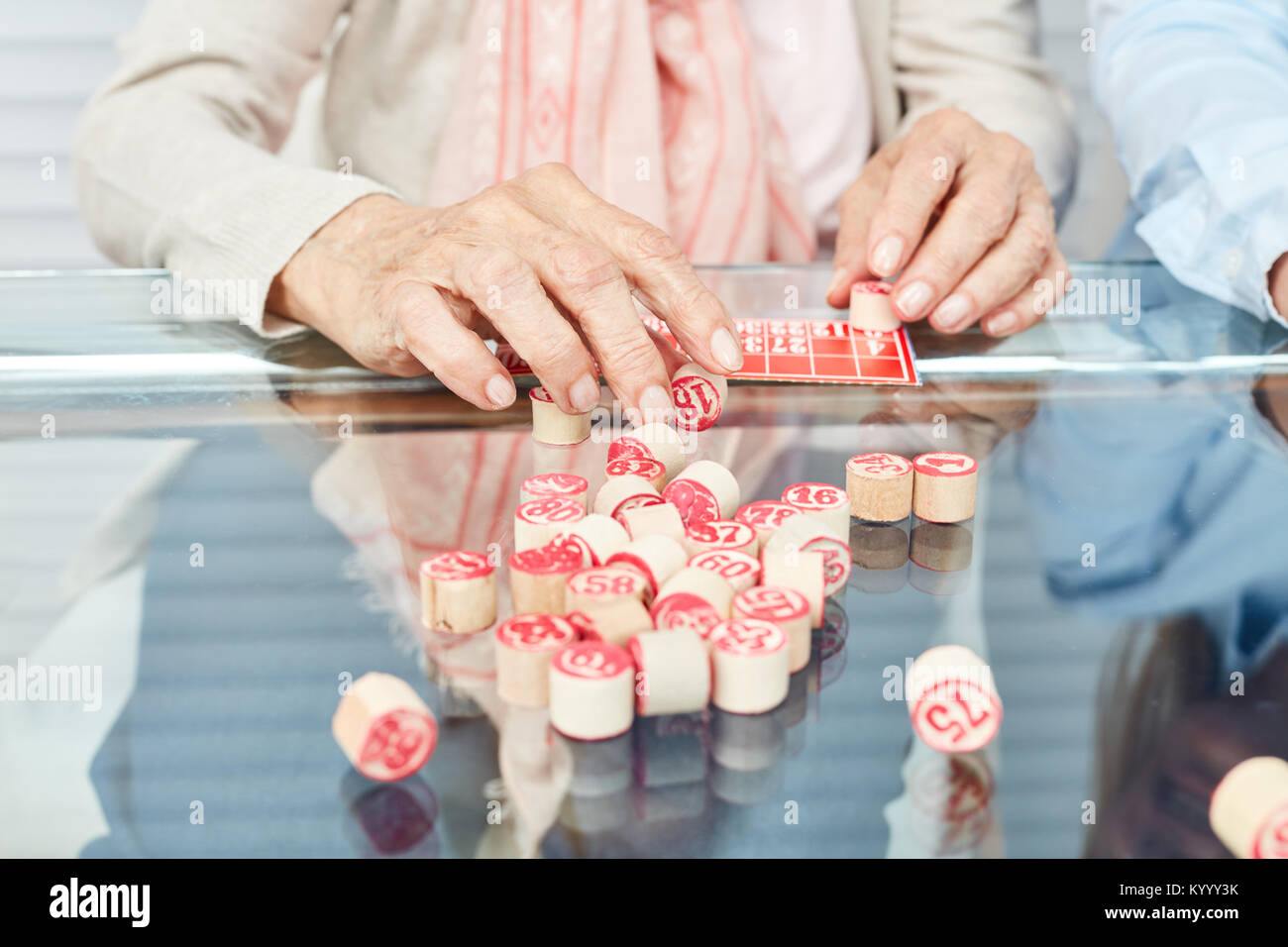 Hands of seniors playing bingo as a memory training in the retirement home Stock Photo