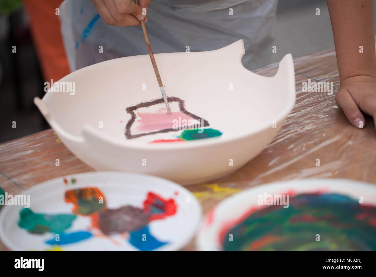 painting ceramics - children painting ceramic dishes Stock Photo