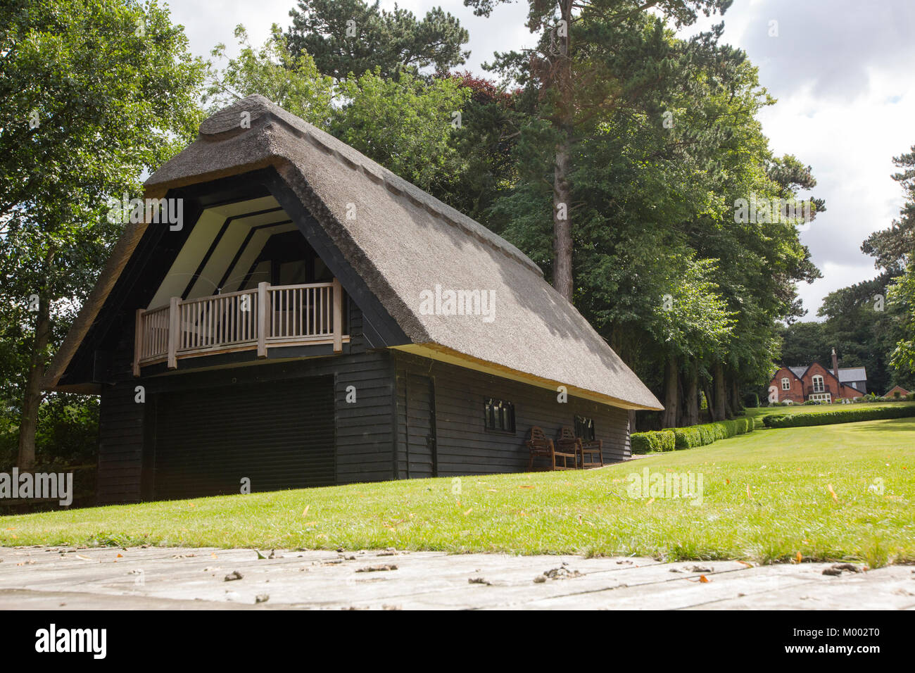 An expensive property with riverside frontage and a thatched boat house