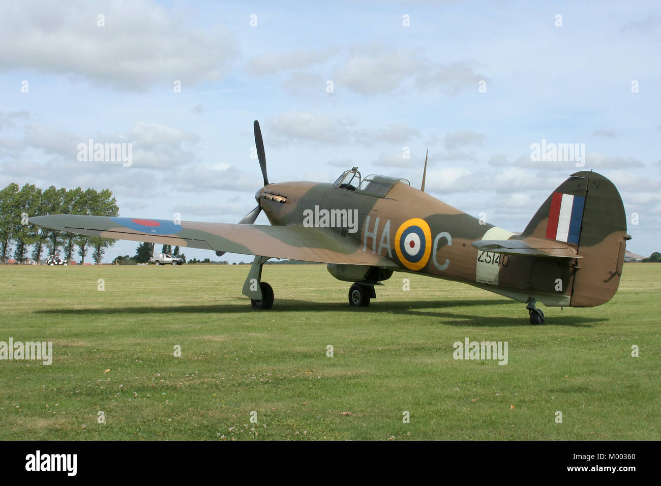 The Historic Aircraft Collections vintage Hawker Hurricane Mk XII sits on the grass during a Rougham airfield airshow prior to displaying. Stock Photo