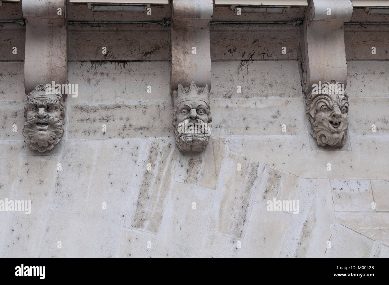 Carved faces of three men on the Pont Neuf in Paris France. Stock Photo