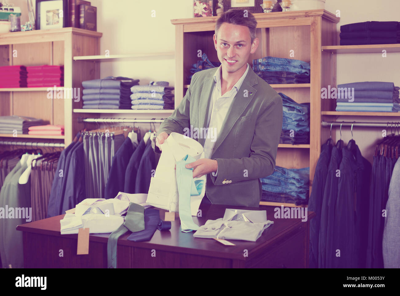 Young man choosing new shirt in male cloths store Stock Photo - Alamy