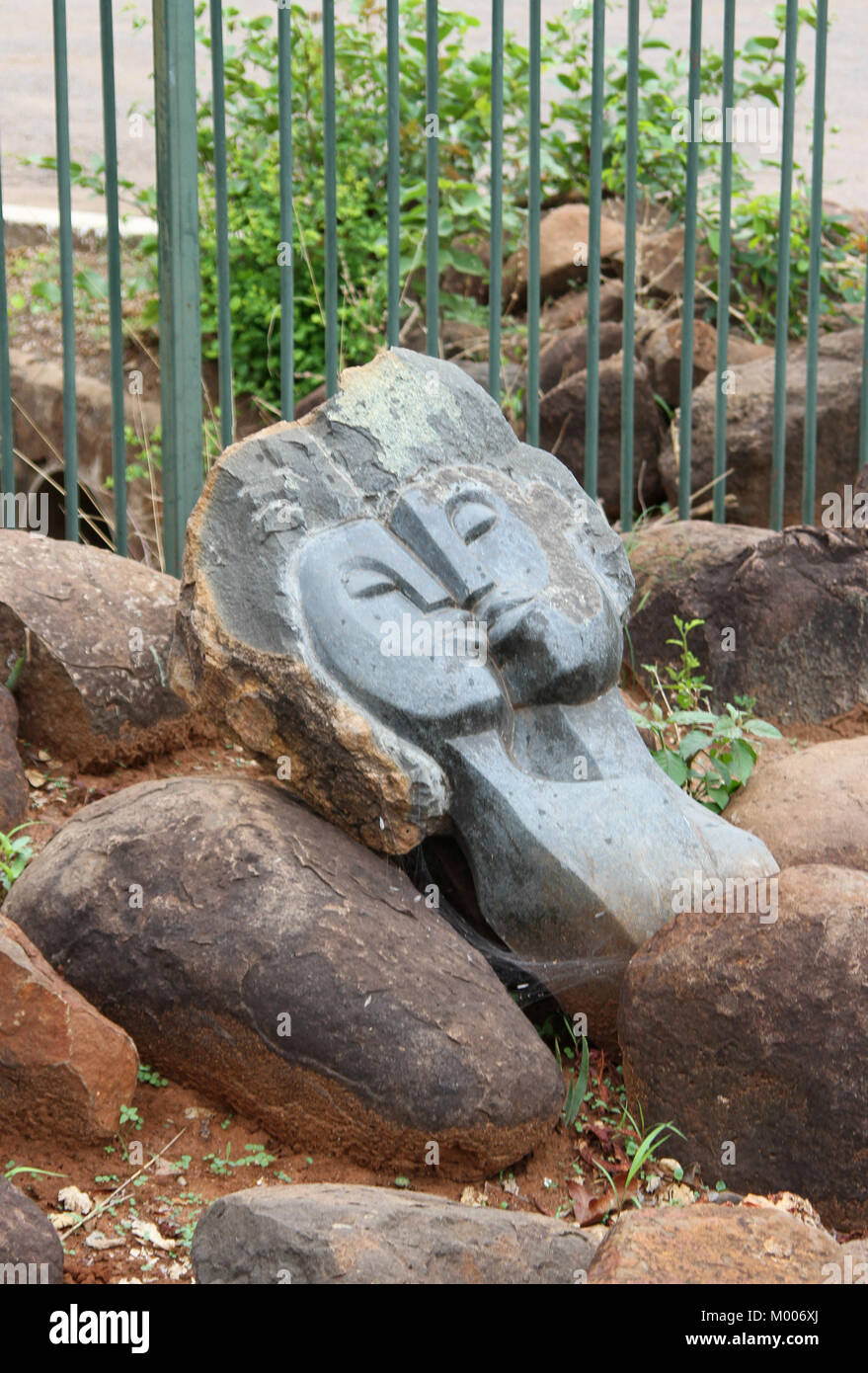 Grey carved stone art statue of two heads kissing, MosiOaTunya
