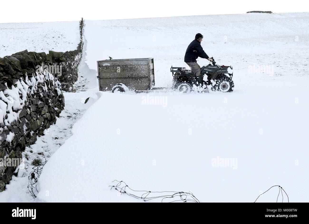 A farmer feeding sheep near Hawes, North Yorkshire, as heavy snow makes it difficult for hill farmers near Hawes to reach their flocks. Stock Photo