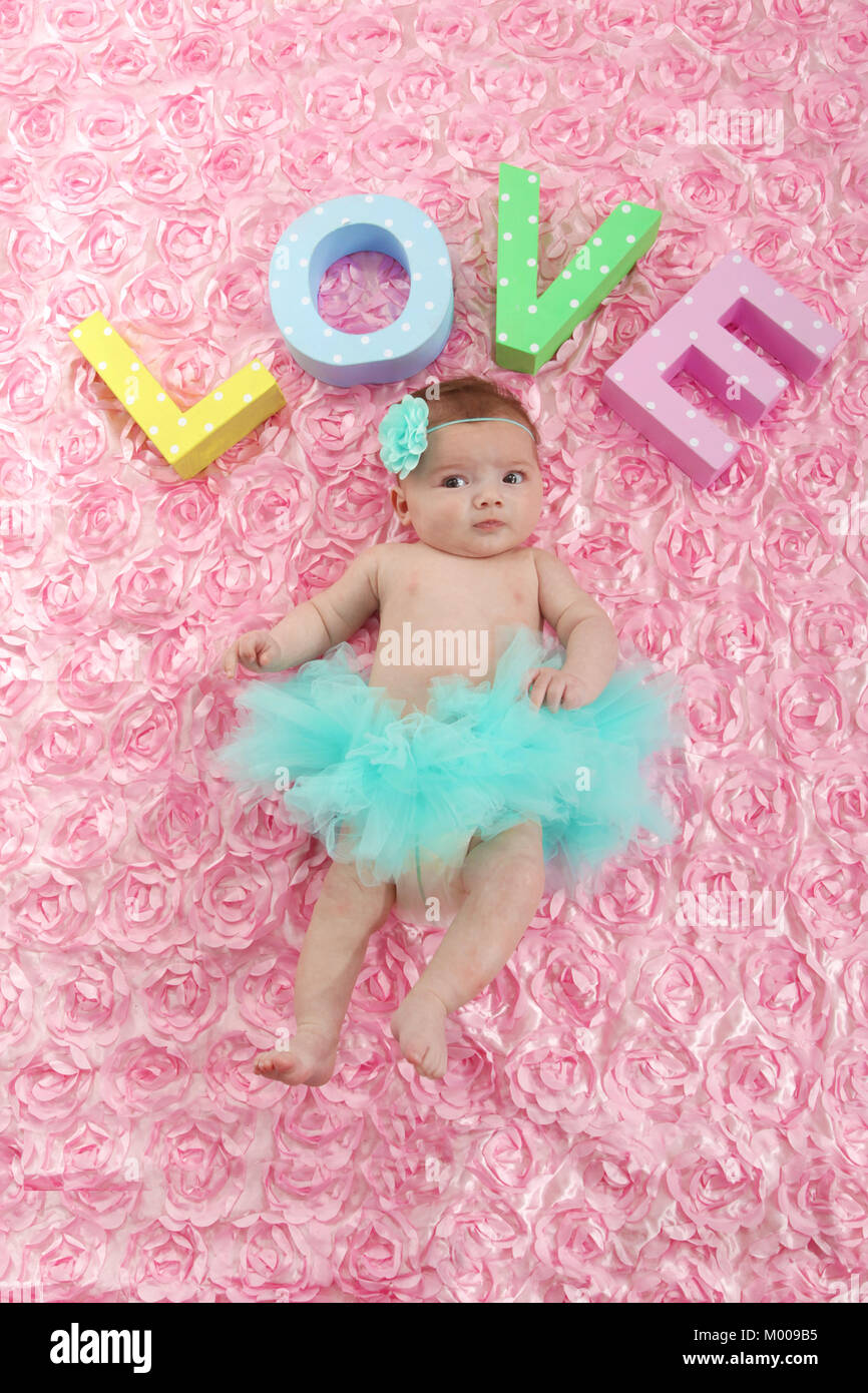 11 week old baby girl in tutu skirt relaxing in nursery, soft play