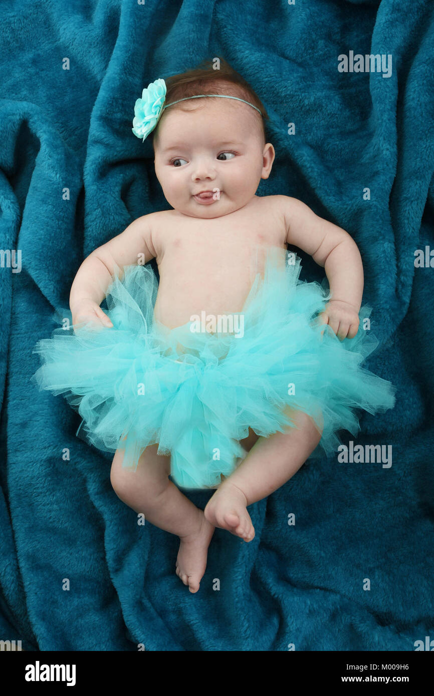 11 week old baby girl in tutu skirt relaxing in nursery, soft play