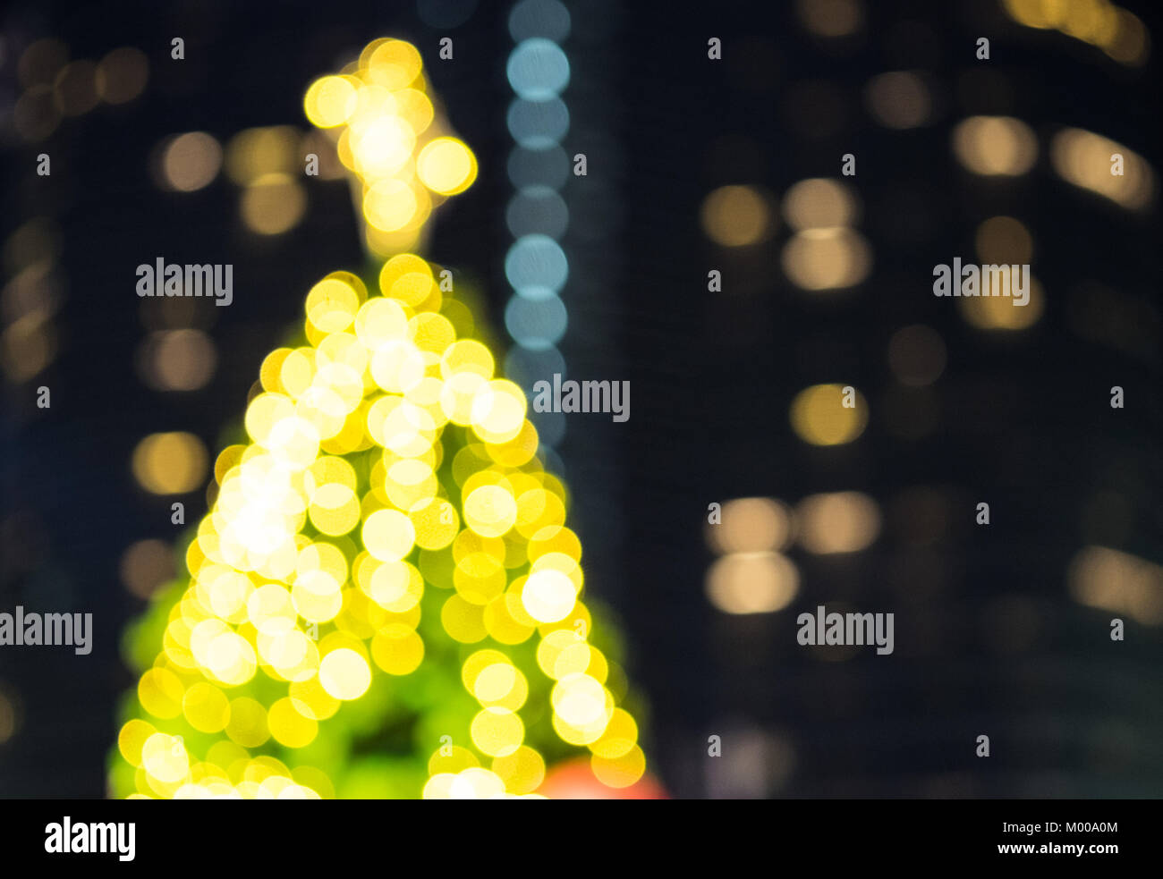 A part of christmas tree colorful bokeh with urban city lighting background. Stock Photo