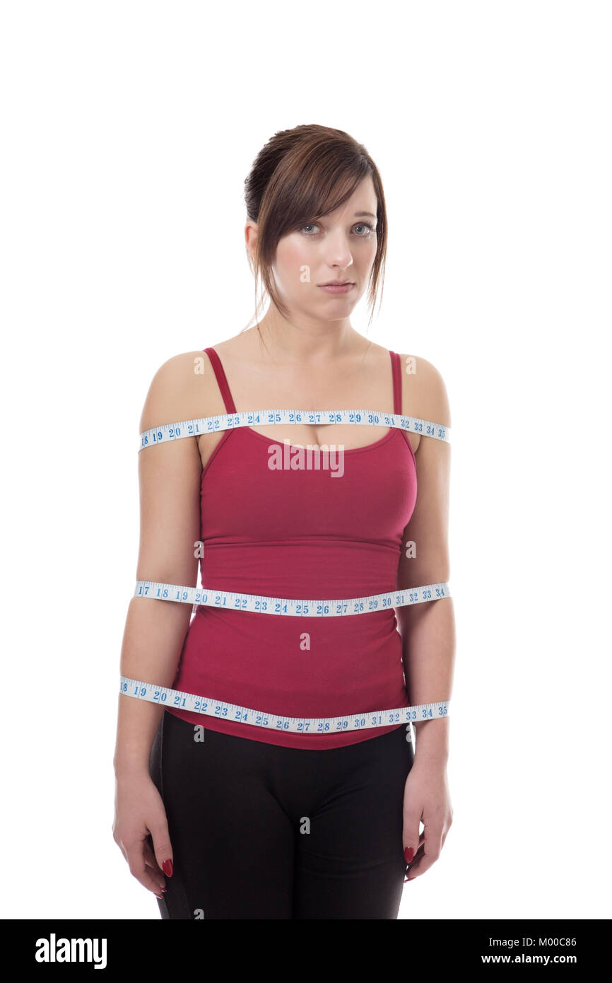 Shot In The Studio Of Young Fitness Woman With A Tape Measure Wrapped Around Body Looking Unsure Stock Photo Alamy
