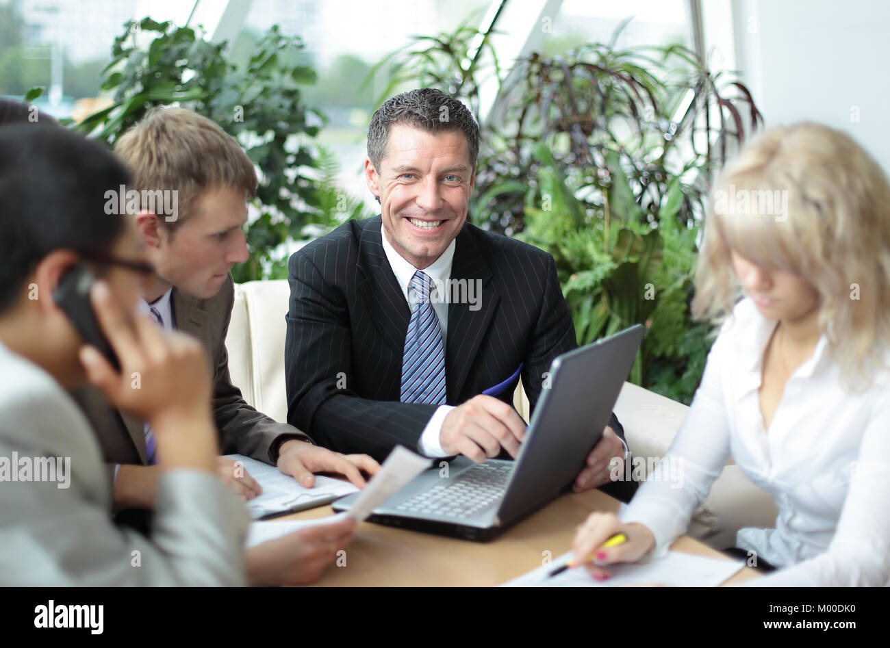 Group of four business people working at meeting Stock Photo - Alamy
