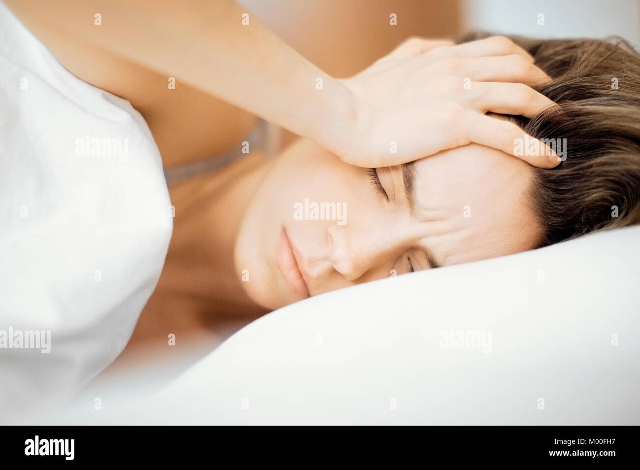 Woman with headache in bed Stock Photo Alamy