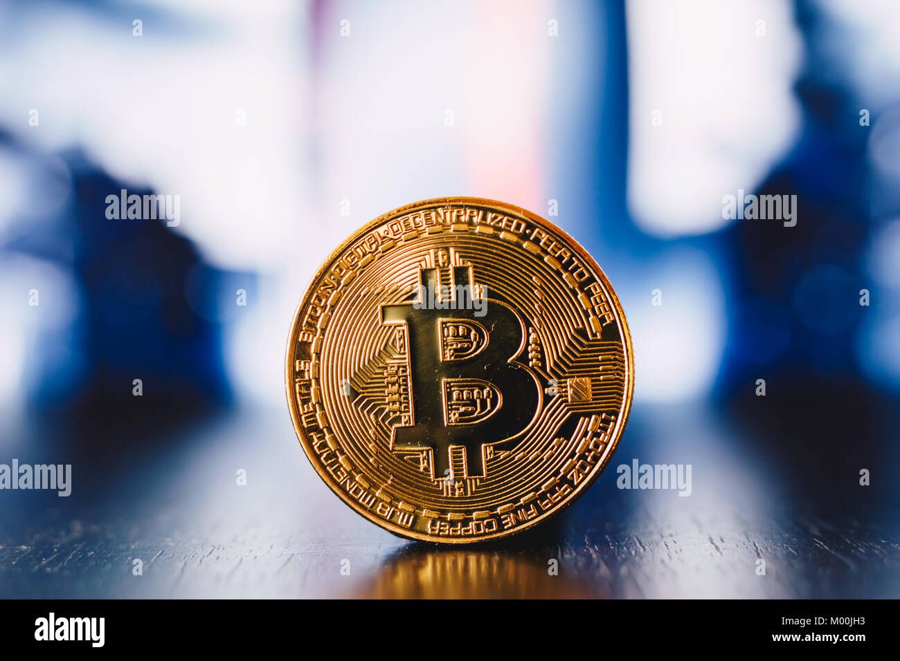 Golden bitcoin coin on a reflection surface with blue background Stock ...