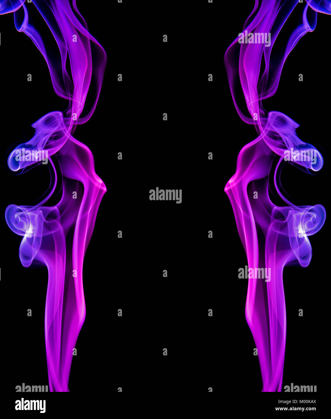 Two vertical mirror-image columns of coloured smoke showing purple hues having artistic appeal as well as providing a central black space for copy Stock Photo