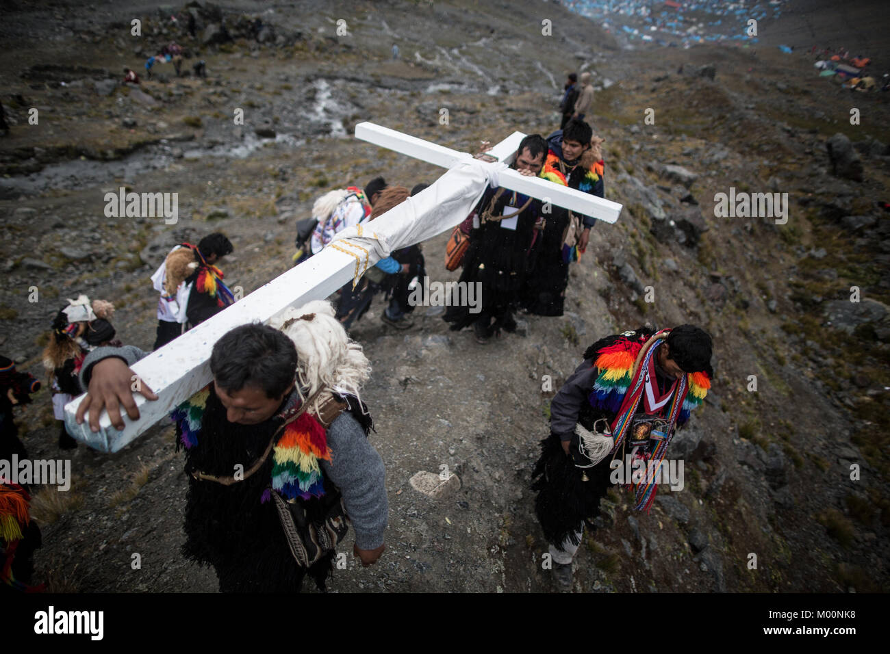 Cusco, Peru. 29th Dec, 2017. Members of the Urubamba nation, ascend to Ausangate Mountain, at 6362m, carrying their cross to be blessed by the Lord of Qoyllur Riti.The pilgrimage includes processions with crosses that climb to the snowy summit of the mountain and then descend the next day.Quyllur Rit'i or Star Snow Festival is a spiritual and religious festival held Annually at the Sinakara Valley in the Cusco Region of Peru. Groups of Quero indigenous people climb Ausangate Mountain, at 6362m, in search of the Snow Star Which is reputedly buried Within the mountain.According to the ch Stock Photo