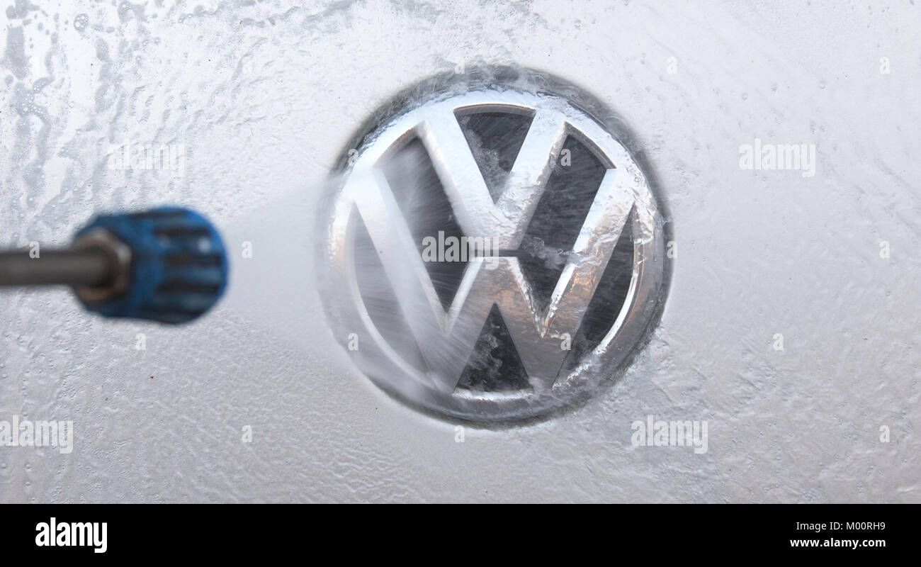 A vehicle's Volkswagen logo is being cleaned at a at a car wash