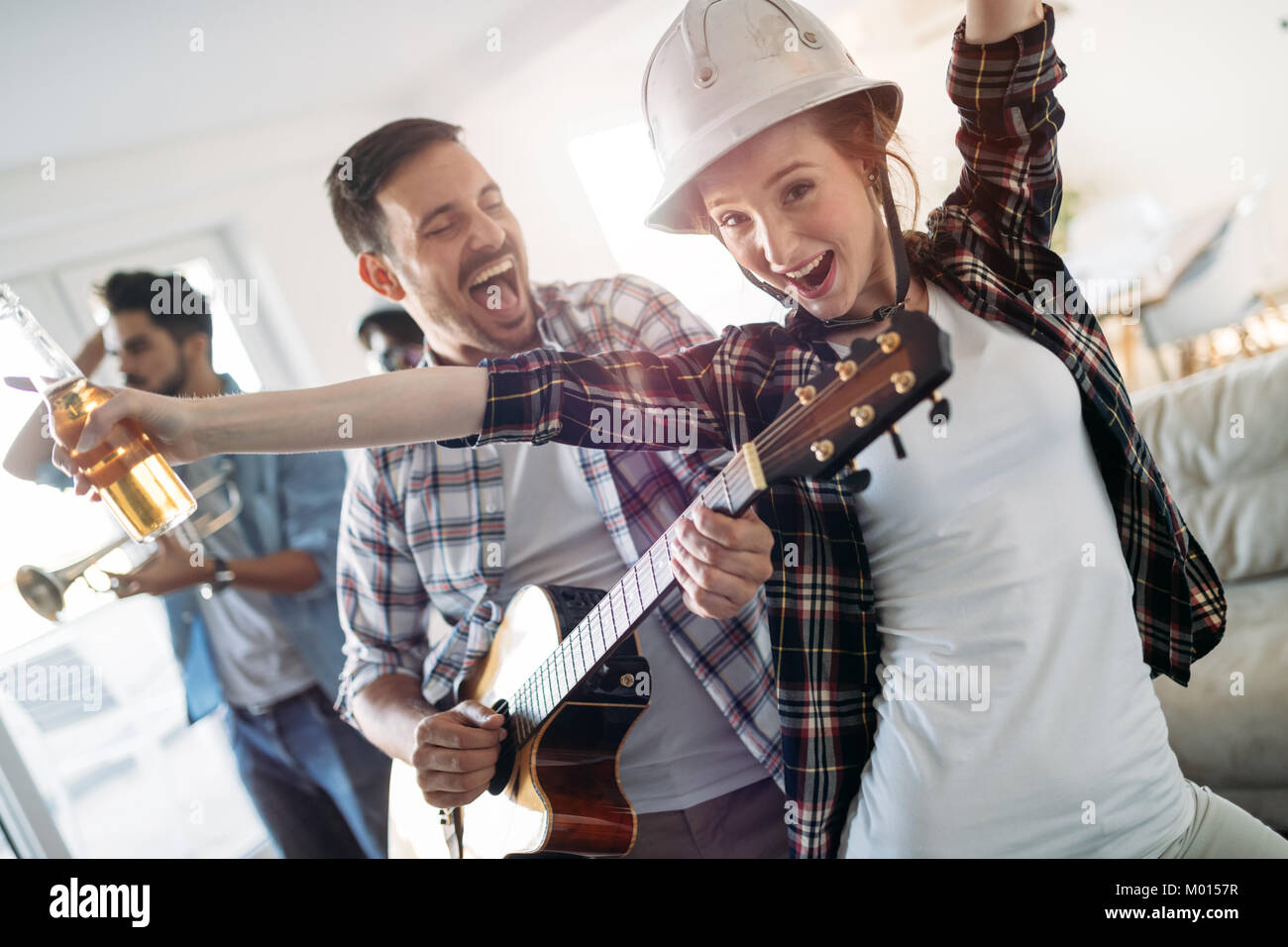 Friends having fun and partying in house and playing music Stock Photo