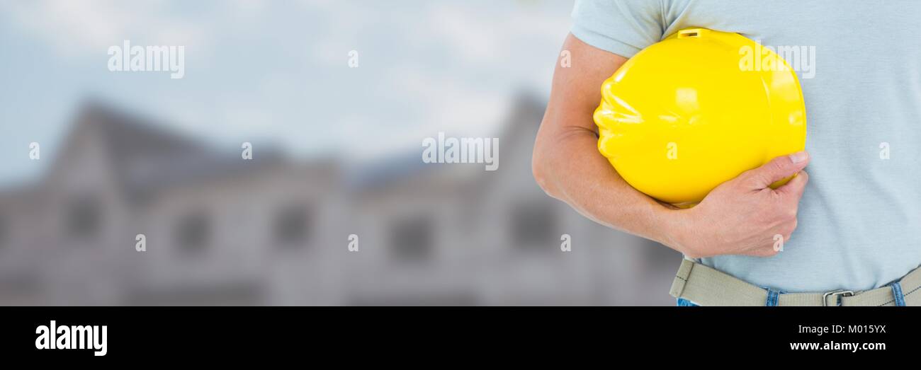 Construction Worker on building site holding helmet Stock Photo