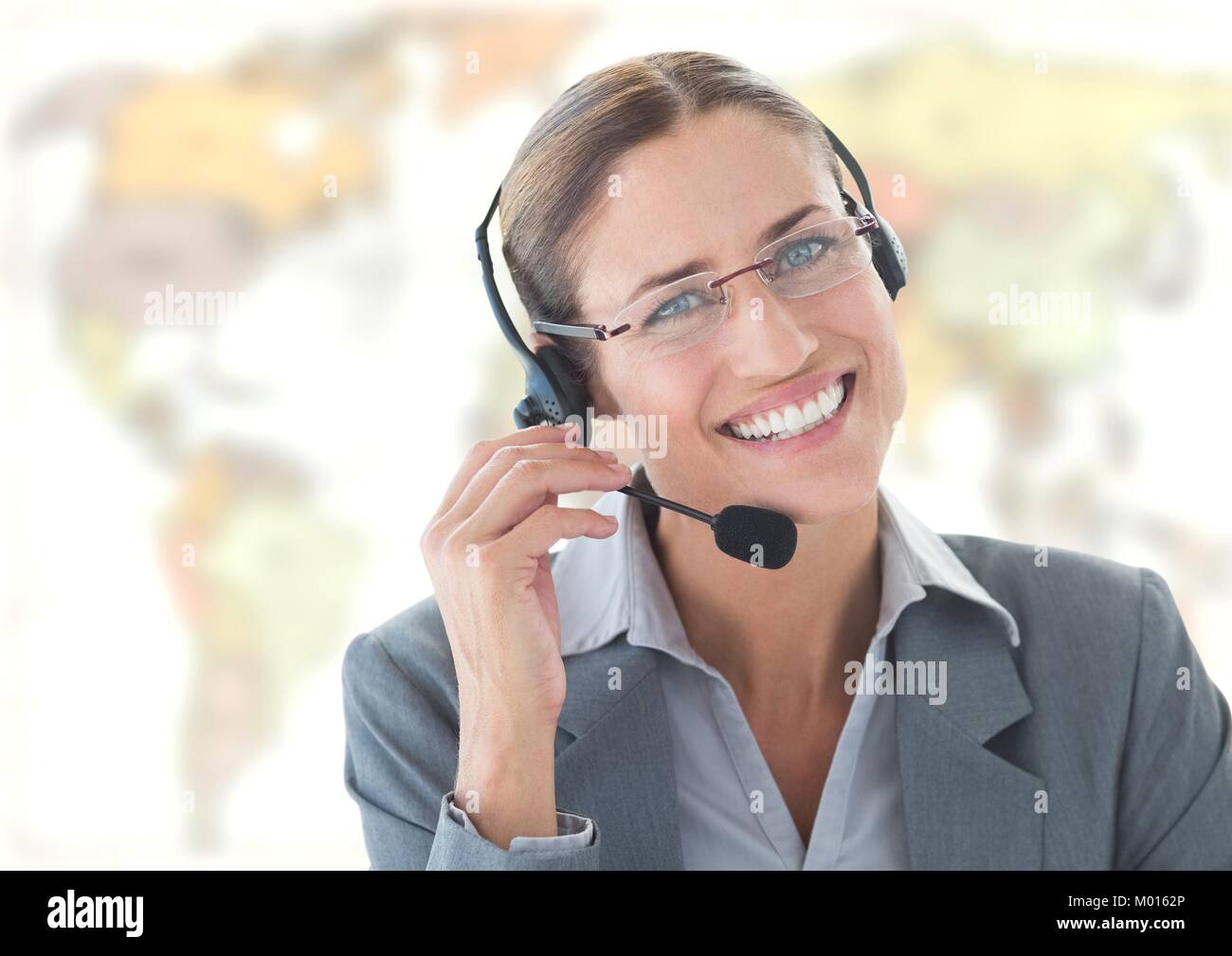 Travel agent woman wearing headset in front of world map Stock Photo